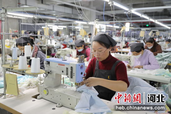 图为一家童装生产企业，工作人员正赶制订单产品。赵一捷 摄